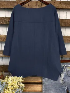 Vue arrière montrant l'ourlet irrégulier et la texture en lin de cette blouse marine