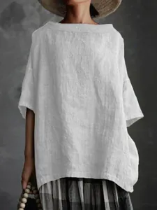 Detailaufnahme einer minimalistischen, weißen und weiten Bluse aus Baumwolle und Leinen