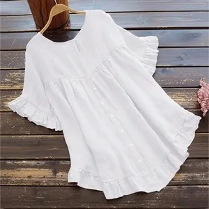 Détail du chemisier en coton et lin blanc avec manches à volants et boutonnage.