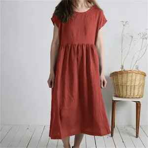 A detailed view of this loose terracotta linen midi dress featuring a pleated waist.