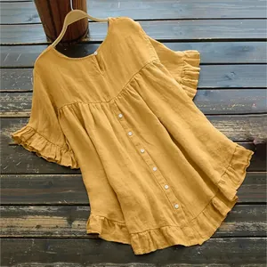 Détail d'une blouse jaune en coton et lin avec manches à volants et boutonnage