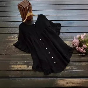 Élégante blouse ample en coton et lin noir avec ourlet à volants et boutons blancs.