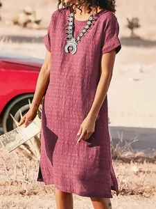 Close-up of mauve textured short sleeve midi dress with side slits on model