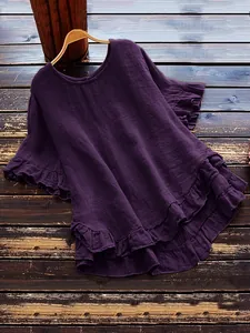 Gros plan d'une blouse violet foncé avec des volants et une texture de tissu froissé