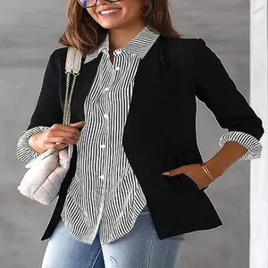 Close-up detail of women's striped long-sleeve button-down shirt paired with a sleek black blazer.