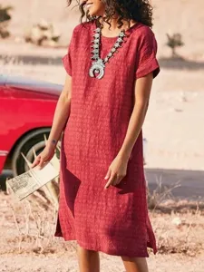 Detail view of a red textured casual dress with side slit in a desert setting