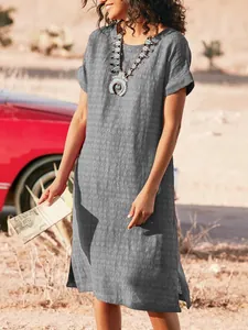 Full view of grey linen-style short sleeve dress with side slits in a desert landscape