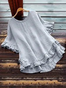 Vue détaillée d'une blouse ample bleu clair avec manches et ourlet à volants élégants