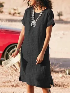 Casual black round neck short sleeve midi dress with side slits in desert setting