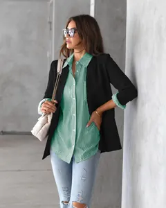 Model wearing a green and white vertical striped button-down shirt with a black blazer