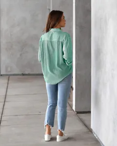 Back view of woman in a green and white striped long-sleeved loose casual blouse