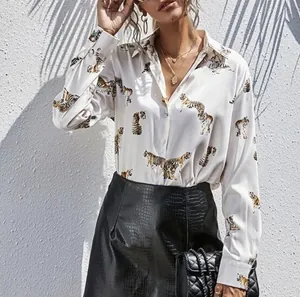 Detail view of tiger print on long-sleeve white silk blouse with button-down front.