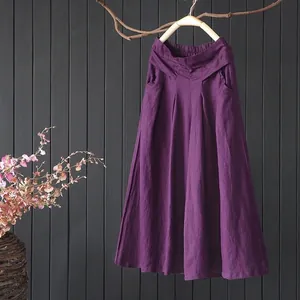 Paarse katoen-linnen broek met wijde pijpen voor een donkere getextureerde houten wandachtergrond