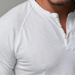 Close-up detail of a white cotton Henley shirt featuring button neckline and slub texture