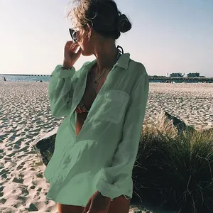 Camisa informal de playa en tela arrugada verde usada por una modelo en la orilla