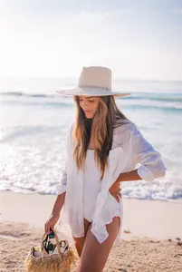 Camisa de playa de lino blanco sobre un traje de baño en una hermosa playa soleada