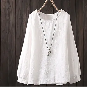 Detalle de una blusa blanca de lino con manga larga y un diseño clásico de cuello redondo.