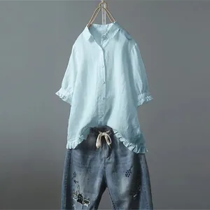 Hellblaues Kurzarmhemd mit Rüschensaum kombiniert mit einer bestickten Jeanshose.