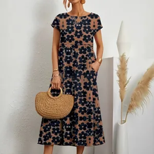 Vestido de verano holgado de algodón y lino con flores y un bolso de paja de estilo bohemio