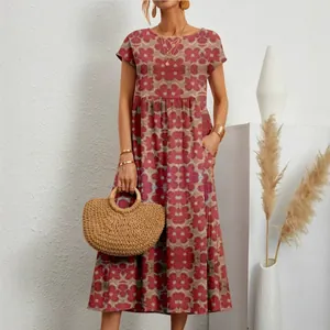 Vista detallada de un vestido largo de algodón y lino floral con bolso de paja