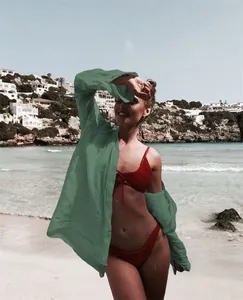 Cubre de playa verde salvia estilo camisa usado por una modelo en la playa