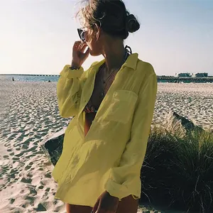 Camisa de playa amarilla de tela arrugada para protección solar en vacaciones costeras