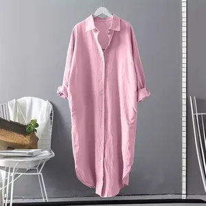 Detailed view of the pink cotton linen long shirt dress hanging against a gray wall.