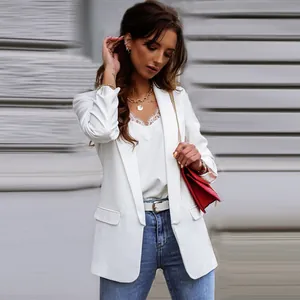 Elegante witte damesblazer met lange mouwen, gecombineerd met kanten top en jeans