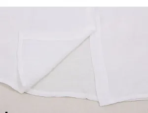 Detalle de la tela blanca transparente de una blusa de playa con abertura lateral