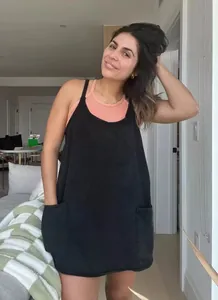 Casual black loose-fitting sleeveless jumpsuit with front pockets on a model indoors
