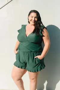 Plus size women's dark green sleeveless V-neck ruffle romper jumpsuit lifestyle view