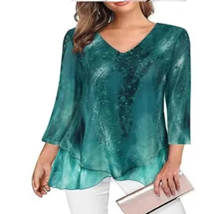 Detailed view of women's green V-neck tunic with asymmetrical layered hem and print.