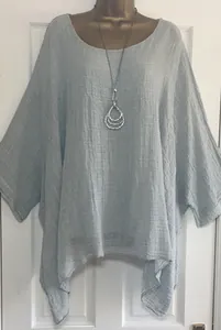 Front detail of a loose light blue textured cotton top featuring an irregular hem