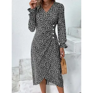 Detailed view of women's long sleeve floral wrap dress with button waist and irregular hem