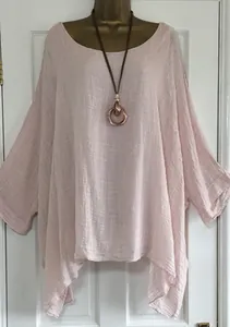 Light pink oversized linen top with irregular hem and wide sleeves shown on a mannequin