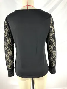 Elegante camiseta negra de manga larga con mangas de encaje floral en un maniquí.