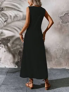 Rear view of a minimalist black sleeveless V-neck maxi dress on a woman posing outdoors