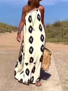 Detail of a bohemian one-shoulder maxi dress with black abstract print in a beach setting.