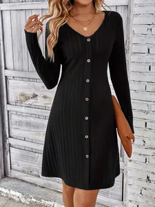 Close-up of elegant black ribbed long-sleeved dress with front button detailing