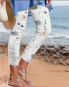 Detailed view of floral capri pants with hollow lace trim at the leg opening.