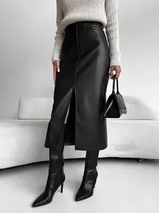 Front slit detail of stylish high-waisted black faux leather midi skirt worn by model