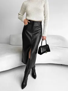 Detail of high-waisted black PU leather midi skirt with chic front slit design