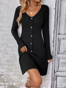 Close-up of black long sleeve button-down ribbed mini dress with V-neckline.