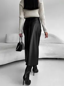 Back view of a chic black faux leather high waist midi skirt styled with black boots