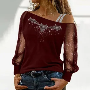 Detailed view of maroon off-shoulder top with rhinestone print and mesh sleeves.