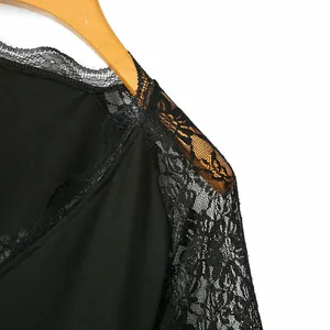 Dettaglio dell'intricato pizzo floreale nero sulla spalla di un top nero con scollo a V