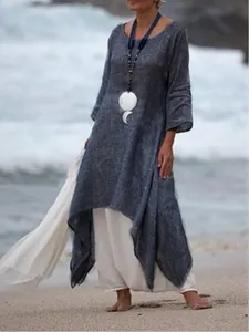 Loose grey cotton linen maxi dress with long sleeves and irregular hem on beach side
