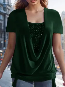 Close-up detail of elegant emerald green cowl neck top with shimmering sequin layer