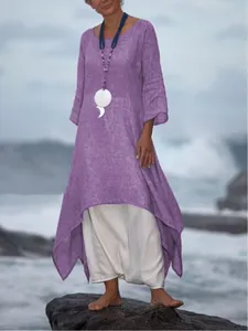Detail view of loose purple cotton linen maxi dress with asymmetric hem by the sea.