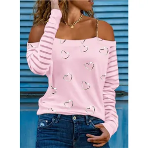 Dettaglio della t-shirt rosa a maniche lunghe con stampe a cuore e spalline a catena